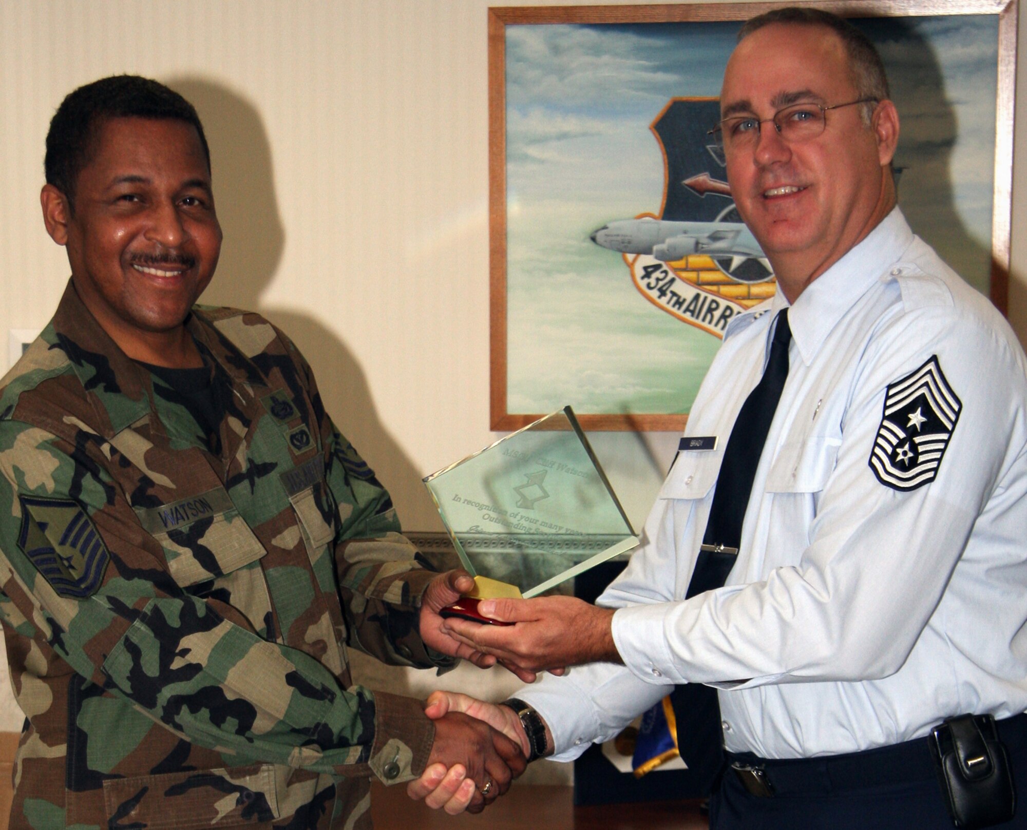 GRISSOM AIR RESERVE BASE, Ind., -- Chief Master Sgt. Larry Brady, 434th Air Refueling Wing command chief, right, presents a plaque to Master Sgt. Clifford Watson, 434th Civil Engineer Squadron, for his service as the unit?s first sergeant. (U.S. Air Force photo/Staff Sgt. Mark Orders-Woempner)