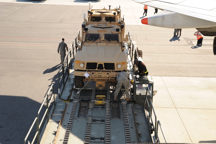 Airmen with the 437th Aerial Port Squadron transport a mine-resistant, ambush-protected all-terrain vehicle from one Tunner 60K Loader to another as they prepare to load it onto a Boeing 747-400 aircraft here Nov. 7. The 437 APS air transportation specialists utilized two 60K loading vehicles together to expedite the loading process. (U.S. Air Force photo/Staff Sgt. Marie Brown)