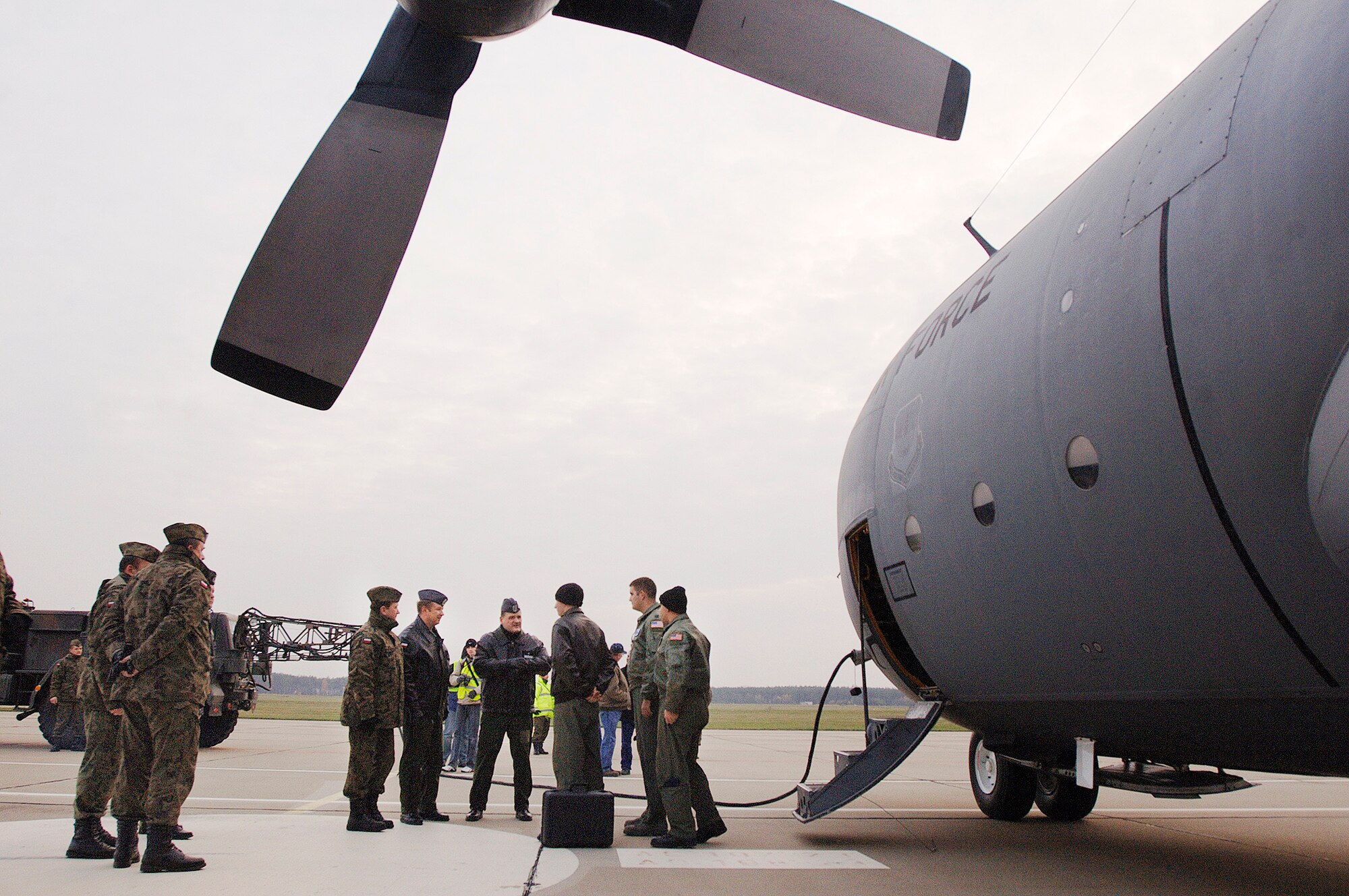 Capt. Tyler Robertson, Capt Ryan Donohoe and Staff Sgt. Eric Kleser are greeted by Polish air force's 33rd Air Base Commander Brig. General Tadeusz Mikutel (fourth from right) and 14th Air Transport Squadron Commander Lt. Col. Mieczyslaw Gaudyn Nov. 2, 2009, at Powidz Air Base, Poland. The aircraft and crew, from Ramstein Air Base, Germany, delivered the C-130 to Poland as part of a program for building partnership capacities between the United States and Poland. Captain Robertson is an aircraft commander, Captain Donohoe is a navigator, and Sergeant Kleser is a flight engineer. (Defense Department photo/Master Sgt. Scott Wagers)