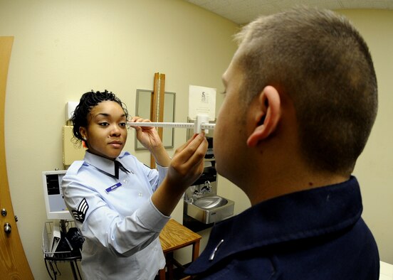 MINOT AIR FORCE BASE, N.D. -- Senior Airman Erika Jenkins, 23rd Bomb Squadron aerospace medical technician, performs an eye test on Airman 1st Class Christopher Stone, 5th Medical Operations Squadron healthcare service management technician, as part of readiness training Nov. 9 here. Eye tests are part of the initial flying class physical and an annual requirement for aircrew members. The medical group was rated outstanding in eight of the 16 topical graded areas during the Air Force Inspection Agency Health Services Inspection and captured an overall excellent rating. (U.S. Air Force photo by Senior Airman Michael Veloz) 
