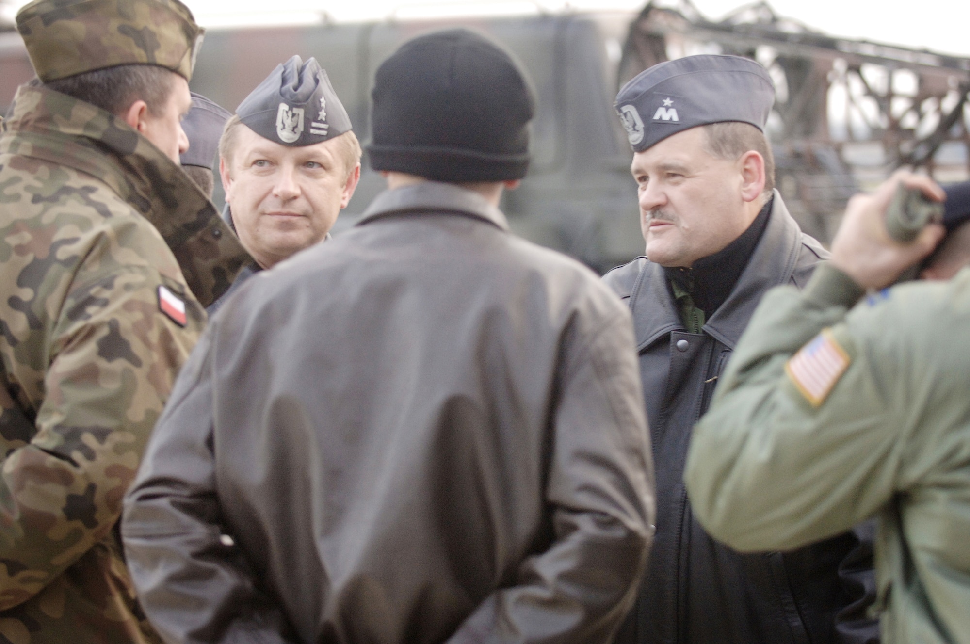 American Airmen talk to Polish air force Brig. Gen. Tadeusz Mikutel (second from left) and Polish air force Lt Col Mieczyslaw Gaudyn (right) after delivering a C-130E Hercules from Ramstein Air Base, Germany, to its final destination Nov. 2, 2009, at Powidz Air Base, Poland. General Mikutel is the Polish air force's 33rd Air Base commander, and Colonel Gaudyn is the 14th Air Transport Squadron commander. The Ramstein AB aircraft and crew, from the 37th Airlift Squadron, delivered the second U.S. Air Force C-130E to Poland as part of a program for building partnership capacities amongst United States allies. (Defense Department photo/Master Sgt. Scott Wagers)
