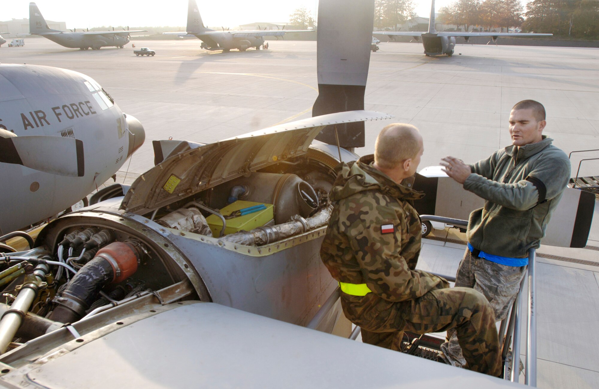 Staff Sgt. Matthew Parker works with Polish air force Chief Warrant Officer Daniel Orlowski in tracing an electrical problem on the No. 4 engine of the last in a series of E-model C-130 Hercules aircraft Oct. 29, 2009, at Ramstein Air Base, Germany. The two mechanics, assigned to the 86th Aircraft Maintenance Squadron and 33rd Air Base Group, respectively, were completing a week-long home station check before the aircraft is transferred to the Polish air force's 14th Airlift Squadron at Powidz Air Base, Poland, as part of a program for building partnership capacities between the United States and its allies. (Defense Department photo/Master Sgt. Scott Wagers)