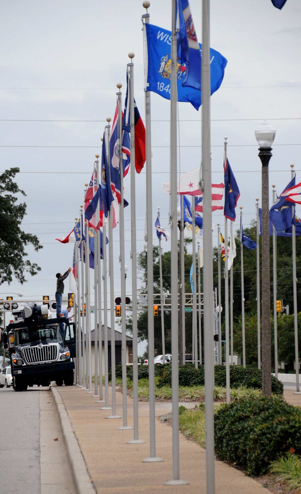 Contractor Jaime Brown removes state flags on Larcher Boulevard in advance of the storm.  (U.S. Air Force photo by Kemberly Groue)
