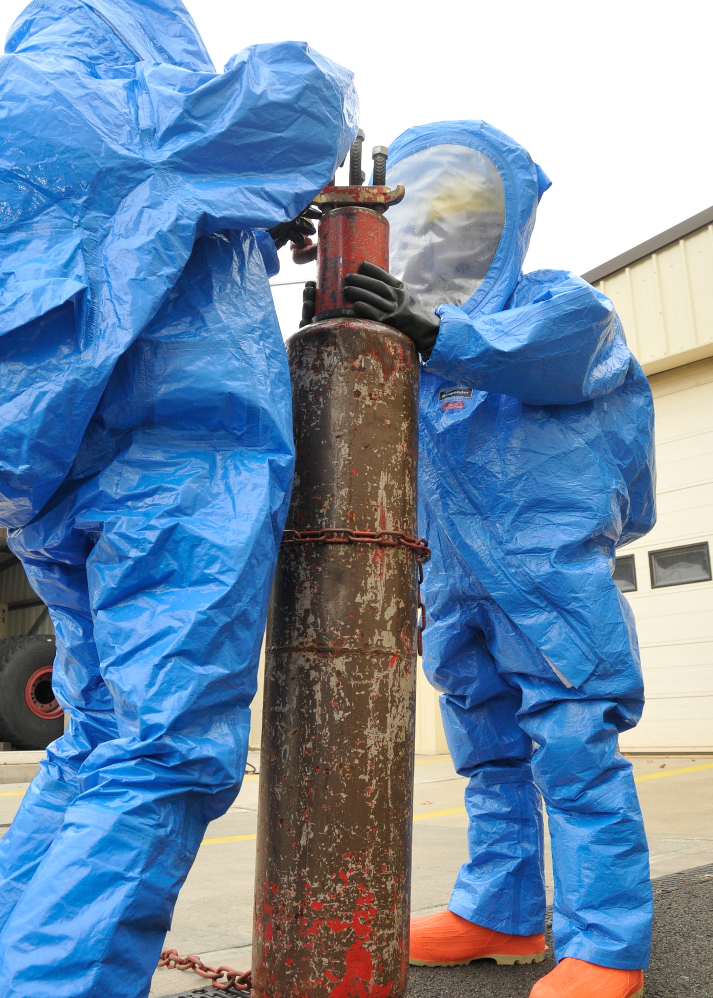 Master Sgt. Vincente Navejas and Airman 1st Class Matthew Kindoll, 48th Medical Group bioenvironmental technicians, fill the holes of a damaged tank filled with simulated hazardous materials as part of the certification process to be an hazardous material technician at RAF Lakenheath, England, Oct 30. (U.S. Air Force photo/Airman 1st Class Eboni Knox)