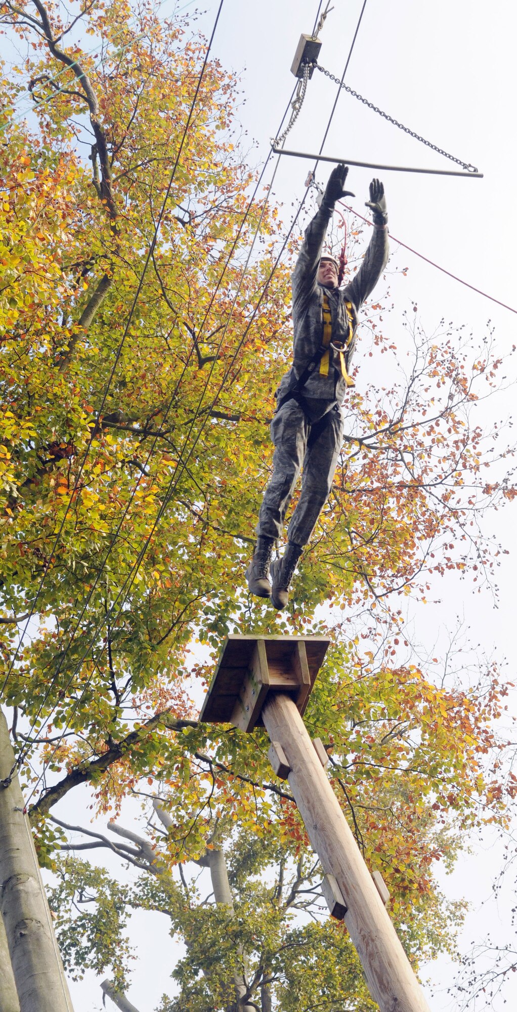 RAF MILDENHALL, England -- In a leap of faith, 1st Lt. Albert Secrest, 48th Equipment Maintenance Squadron, dives from a 50-foot tall platform to grab a bar on the high-ropes course at RAF Marham Nov. 9. This event was one of 40 offered at the camp's Leadership, Ethos and Air Power Day to help build teamwork and leadership skills for American and British Air Forces. Forty Airmen from RAFs Mildenhall and Lakenheath participated in the event. (U.S. Air Force photo/Senior Airman Thomas Trower)