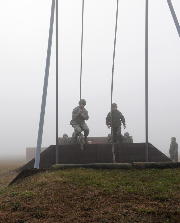 RAF MILDENHALL, England -- Master Sgt. Matthew Poole, 48th Munitions Squadron (left), swings over a sand pit during Leadership, Ethos and Air Power Day at RAF Marham Nov. 9. About 40 Airmen from RAFs Mildenhall and Lakenheath participated in the leadership building opportunities with their British counterparts. The event is normally hosted three times a year for RAF troops. The overall goal is to foster teambuilding and teach effective leadership techniques. (U.S. Air Force photo/Senior Airman Thomas Trower)