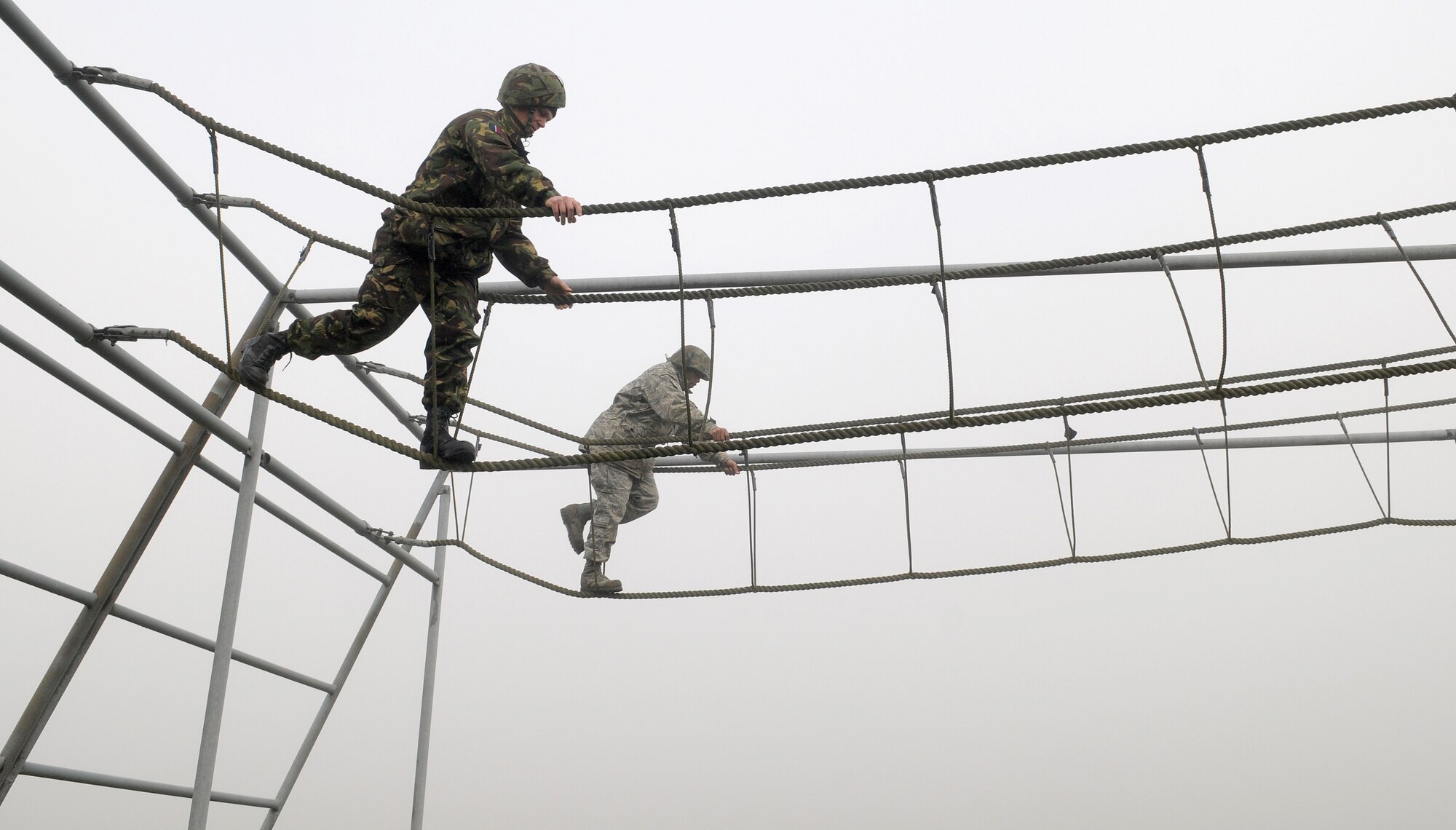 RAF MILDENHALL, England -- A British airman (left) and 1st Lt. Xzavior Hill, 100th Civil Engineer Squadron, traverse a rope bridge as part of the Ultimate Challenge 2 activity of Leadership, Ethos and Air Power Day at RAF Marham Nov. 9. About 40 Airmen from RAFs Mildenhall and Lakenheath participated in the leadership building opportunities with their British counterparts. The event is normally hosted three times a year for RAF troops. The overall goal is to foster teambuilding and teach effective leadership techniques. (U.S. Air Force photo/Senior Airman Thomas Trower)
