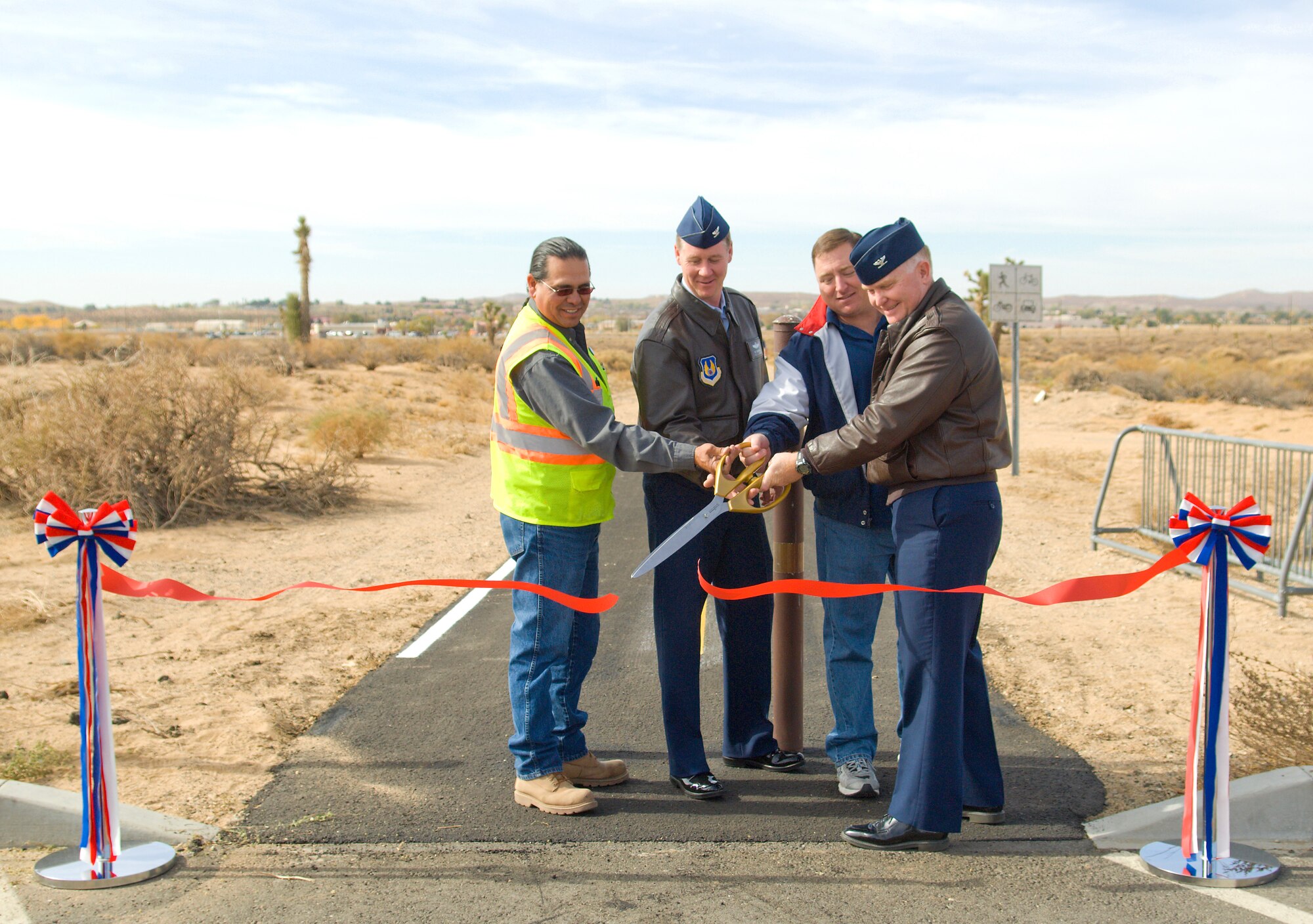 From left to right: Sam Garcia, Granite Construction, Col. William Thornton, 412th Test Wing commander, Pete Smith, Rosburg Fitness Center director and Col. Jerry Gandy, 95th Air Base Wing commander, cut the ribbon officially reopening the run/bike path behind the fitness center Nov.9. The path, which was closed to be refurbished, officially reopened Nov. 9. (Air Force photo/Mike Cassidy)