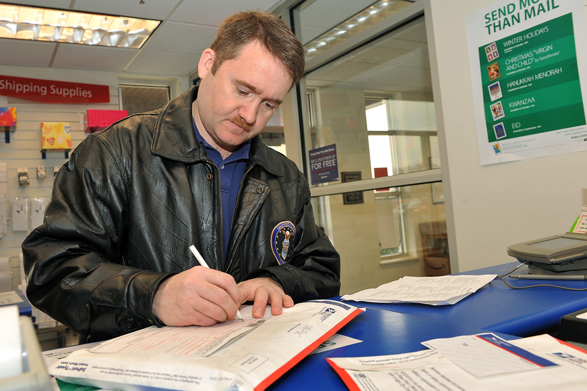 OFFUTT AIR FORCE BASE, Neb. -- Senior Master Sgt. Jonathan Morris, Air Force Weather Agency superintendent of standards and evaluation, fills out a customs label inside the Offutt Post Office to send off a package to Germany Nov. 6. The U.S. Postal Service has established mailing deadlines to ensure military members deployed to southwest Asia and other overseas locations don't miss out of holiday cheer from friends and loved ones. 
U.S. Air Force photo by: Charles Haymond
