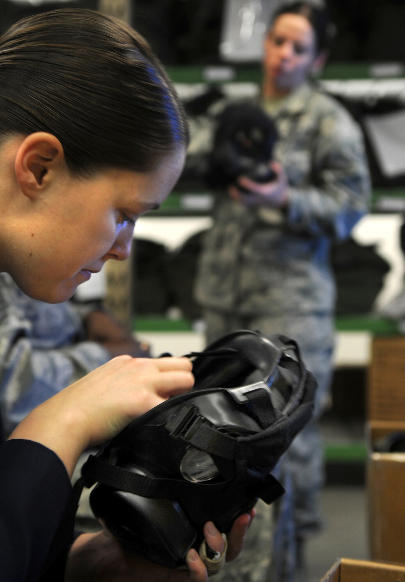 U.S. Air Force Senior Airman Tara Horvat (left), 86th Security Forces Squadron, assembles her issued M50 protective mask as Airman 1st Class Renee Malsom (right), 886th Civil Engineer Squadron, Ramstein Air Base, briefs a class on the proper usage of the new M50 protective mask, November 9, 2009.  The M50 protective mask will be replacing the current MCU-2P protective mask.  (U.S. Air Force photo by Staff Sgt. Charity Barrett)