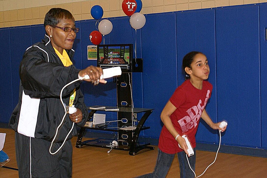 LANGLEY AIR BASE, Va. -- Rochelle Pailin, 1st Force Support Squadron Youth Programs school-age assistant, challenges Erika Moore, daughter of Senior Master Sgt. Maurice Moore, Air Combat Command A-4Q, to a game of tennis on a Wii system Nov. 7 at the Shellbank Youth Center.  The Youth Programs Family Fun Day was one of many events the 1st FSS held in honor of Military Family Week. Nov.1-7. (Courtesy photo/Cynthia Bush)