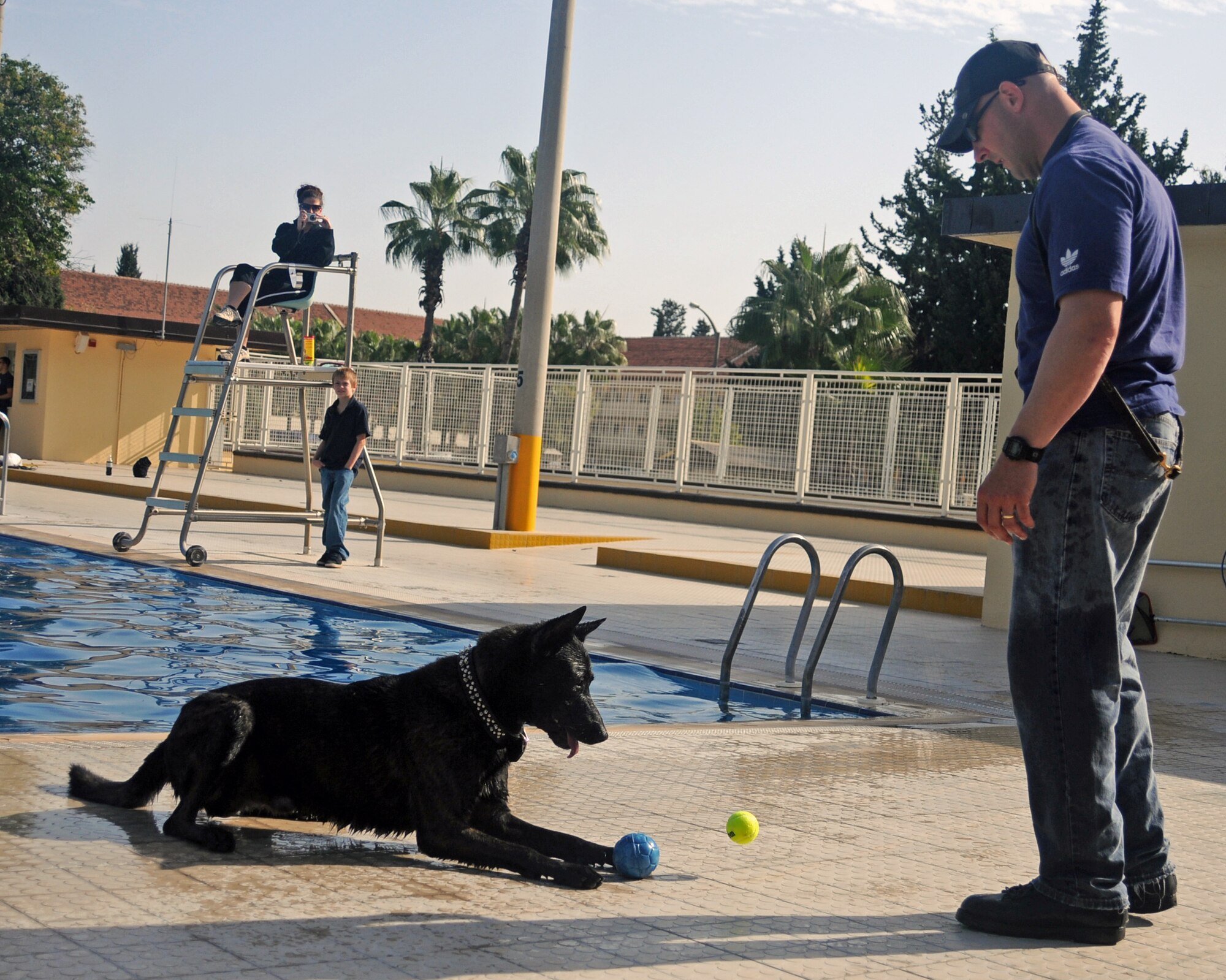 Capt. George Hern, 39th Security Forces Squadron, gives commands to his dog during “Dog Daze” at Incirlik’s base pool Saturday, Nov. 7, 2009. More than 20 dogs and their owners came out to the base pool for an entertaining afternoon of ball catching and jumping from the diving board to say farewell to the pool until next year’s opening. (U.S. Air Force photo/Senior Airman Sara Csurilla)
