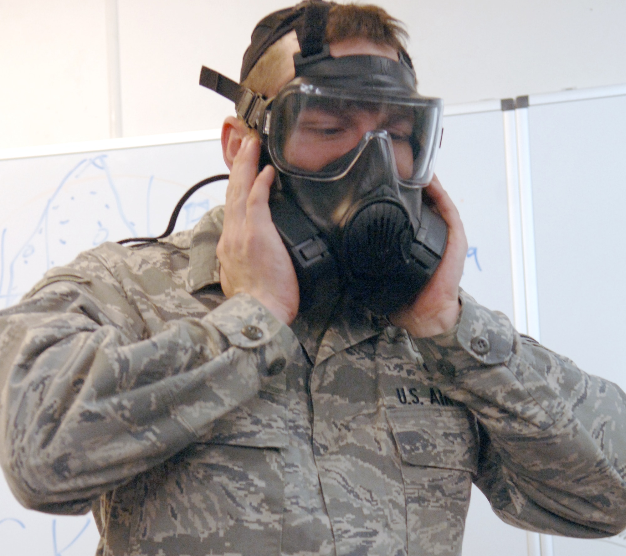 U.S. Air Force Airman 1st Class Michael Balbaugh, 886th Civil Engineer Squadron readiness and emergency management apprentice, demonstrates how to check the seal of the M-50 Joint Service General Purpose Mask, Nov. 5, 2009, Ramstein Air Base, Germany. The mask has two filters as opposed to the one canister filter on the MCU-2 mask.  (U.S. Air Force photo by Senior Airman Amanda Dick)