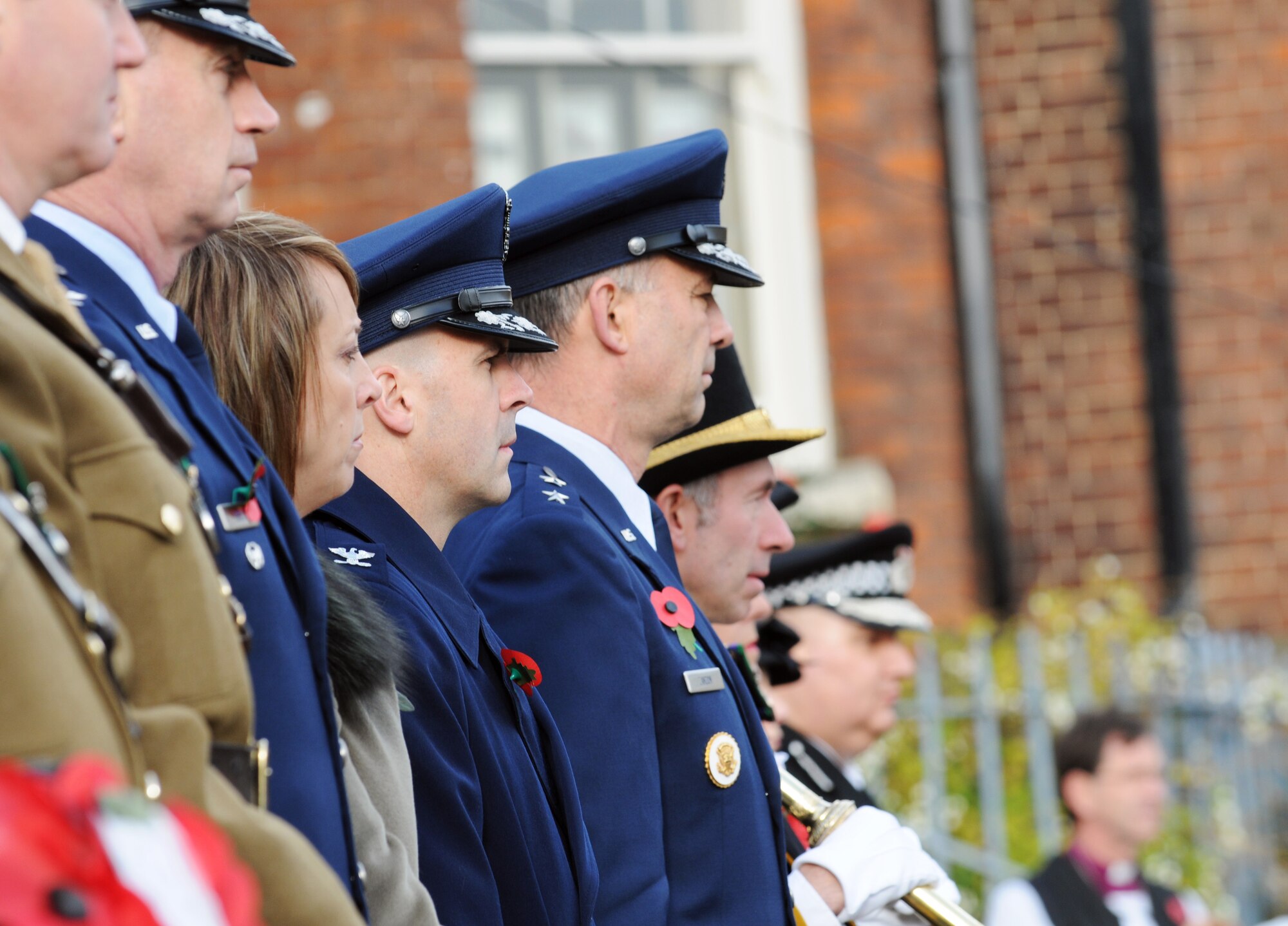 RAF MILDENHALL, England -- The Air Force-blue uniforms of Cols. Lawrence Reed (left), Chad Manske (middle) and Maj. Gen. Mark Zamzow stand out among local dignitaries at a Remembrance Day ceremony at Angel Hill, Bury St. Edmunds Nov. 9. General Zamzow, 3rd Air Force vice commander, presented a poppy wreath along with Colonels Manske, 100th Air Refueling Wing commander, and Reed, 48th Fighter Wing vice commander, at the base of a memorial. British and American forces participated in the event that was one of thousands across the country. (U.S. Air Force photo/Senior Airman Thomas Trower)