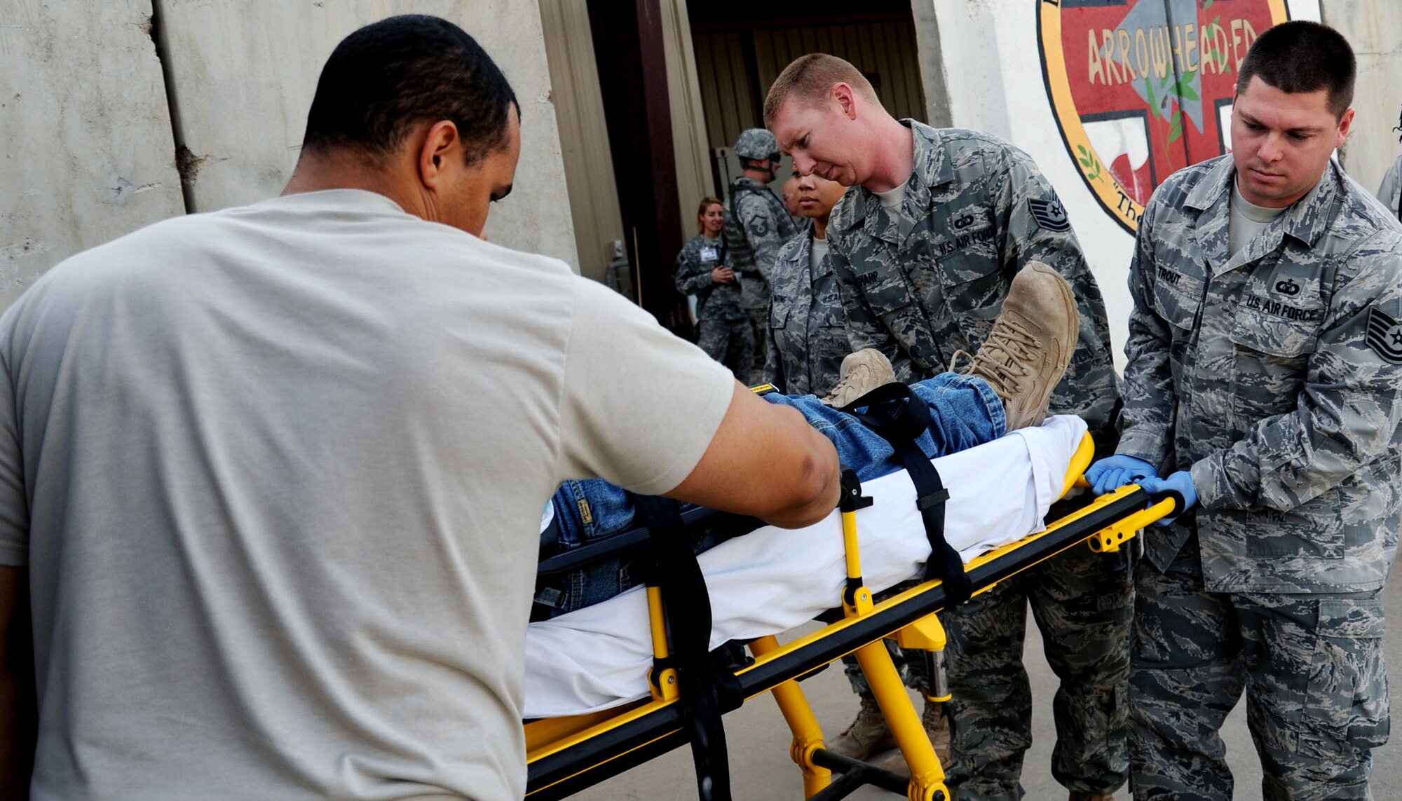 JOINT BASE BALAD, Iraq -- Tech. Sgts. Brandon Sharp and Jeremy Trout, hospital volunteers from the 332nd Expeditionary Operations Support Squadron, unload a patient from an ambulance at the Air Force Theater Hospital Nov. 3, 2009. Hospital volunteers spend their free time assisting hospital personnel in a variety of ways, and are available in the event of a mass casualty. (U.S. Air Force photo/Senior Airman Christopher Hubenthal)