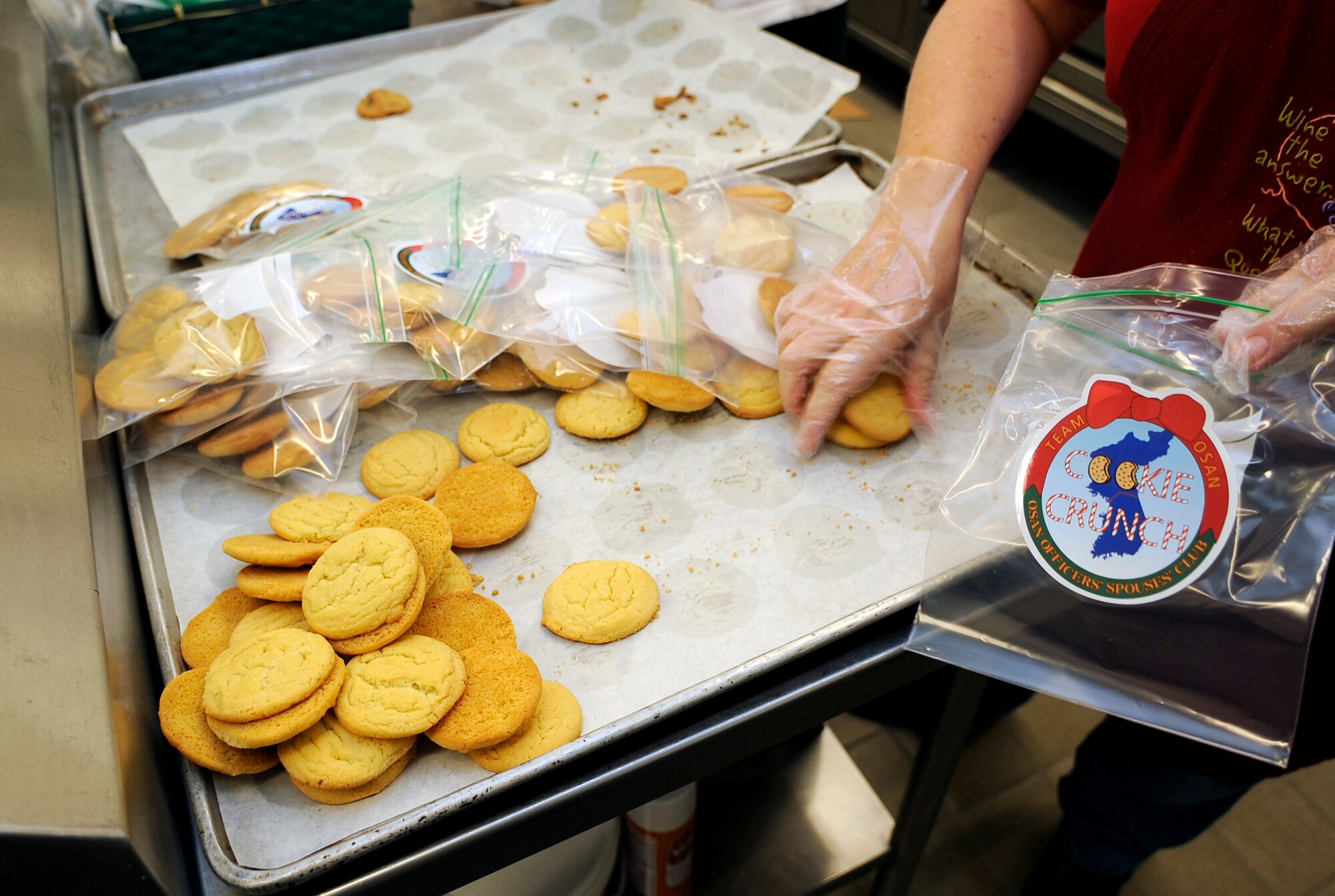 Karen Forster fills bags with cookies during the annual "Cookie Crunch" at Osan Air Base, Republic of Korea.  The Cookie Crunch program is hosted by the Osan Officer's Spouses Club and base leadership to bring a taste of home to all Airmen, Soldiers, Sailors, Marines and Korean Airmen on the peninsula. (U.S. Air Force photo/Staff Sgt. Brian Ferguson)





