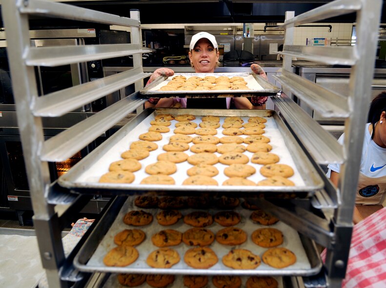 Rebecca Mattison removes a tray of cookies from the oven and loads it onto a cart during the annual "Cookie Crunch" at Osan Air Base, Republic of Korea. The Cookie Crunch program is hosted by the Osan Officer's Spouses Club and base leadership to bring a taste of home to all Airmen, Soldiers, Sailors, Marines and Korean Airmen on the peninsula. (U.S. Air Force photo/Staff Sgt. Brian Ferguson)





