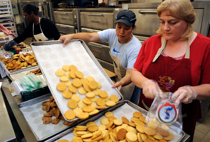 Elsa Wong, left, replenished a tray of sugar cookies as Karen Forster fills bags with cookies at Osan Air Base, Republic of Korea, during the annual "Cookie Crunch".  The Cookie Crunch program is hosted by the Osan Officer's Spouses Club and base leadership to bring a taste of home to all Airmen, Soldiers, Sailors, Marines and Korean Airmen on the peninsula. (U.S. Air Force photo/Staff Sgt. Brian Ferguson)




