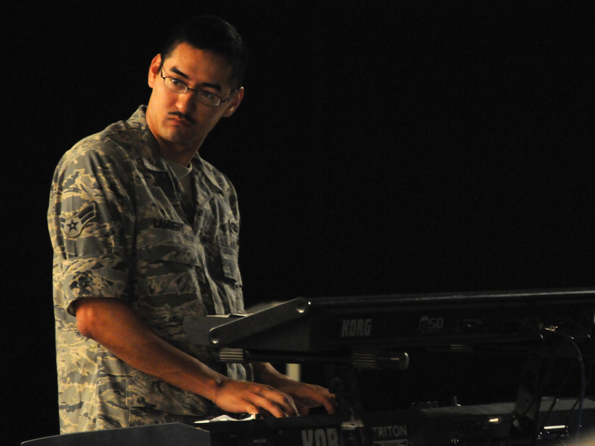Airman 1st Class Dennis Lambert, Air Forces Central Command band keyboardist, performs with the band Sirocco for an audience of deployed servicemembers at an undisclosed location in Southwest Asia, Nov. 7, 2009. Sirocco is deployed from Lackland Air Force Base, Texas in support of operations Iraqi Freedom and Enduring Freedom. (U.S. Air Force Photo/Tech. Sgt. Jason W. Edwards)