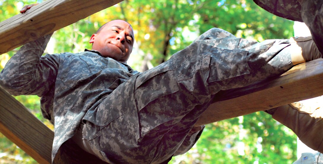 A U.S. Army infantry recruit tries to hang on as he attempts to swing ...