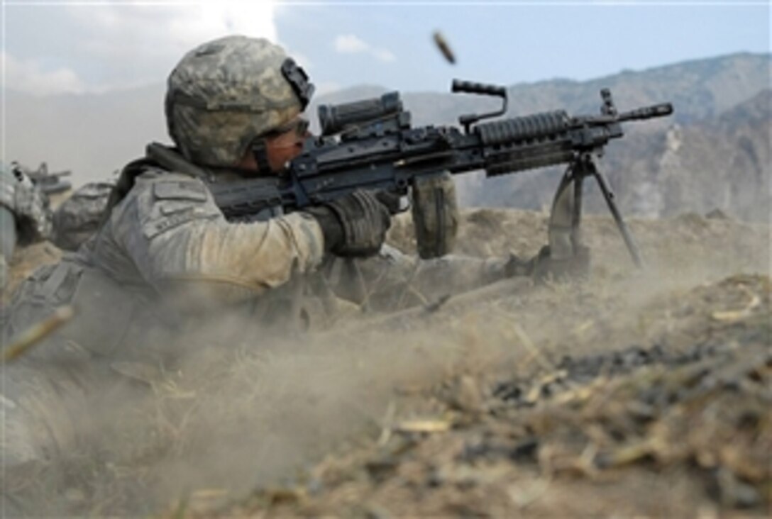 U.S. Army Pvt. John Stafinski fires his M-249 squad automatic weapon during a three-hour gun battle with insurgent fighters in the Waterpur Valley, in Kunar province, Afghanistan, on Nov. 3, 2009.  Stafinski is an infantryman, with Charlie Company, 2nd Battalion, 12th Infantry Regiment, 4th Infantry Division.  