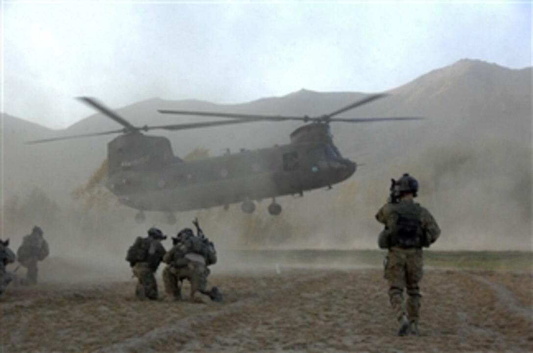 Soldiers of the joint force brace themselves against the CH-47 Chinook helicopter rotor wash at a helicopter landing zone in Zanakhan District, of Ghazni province, Afghanistan, on Oct. 31, 2009.  