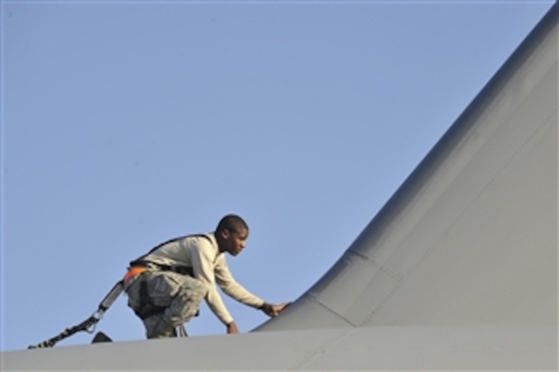 U.S. Air Force Airman 1st Class Alexander McCall, a crew chief with the 315th Aircraft Maintenance Squadron, searches for discrepancies on top of a C-17 Globemaster III aircraft during an inspection at Charleston Air Force Base, S.C., on Nov. 4, 2009.  Inspections are required for all C-17 aircraft to ensure operational integrity during flight.  