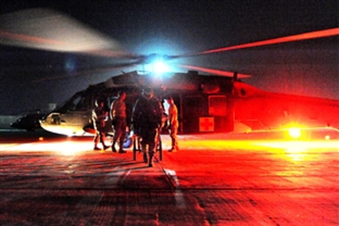 Volunteers for the patient administration and disposition section of the 332nd Expeditionary Medical Support Squadron transport a patient away from an HH-60G Pavehawk toward the intensive care unit area of the Air Force Theater Hospital Nov. 2, 2009 on Joint Base Balad, Iraq. Volunteers assist in the section's manpower and will respond if available in the event of a mass casualty.