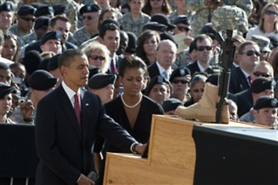 Taking part in a Nov. 10, 2009, memorial service on Fort Hood, Texas, President Barack Obama and First Lady Michelle Obama look at the photograph of one of the victims of the Nov. 5 shooting rampage that left 13 dead and 38 wounded.