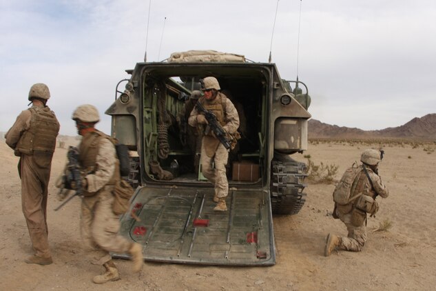 Marines with 2nd Squad, 2nd Platoon, Company G, 2nd Battalion, 7th Marine Regiment, 'disembark' from an Amphibious Assault Vehicle Nov. 11 as they attack the Combat Center's Range 205. Co. G is the battalion's mechanized company for their upcoming deployment with the 31st Marine Expeditionary Unit in January.