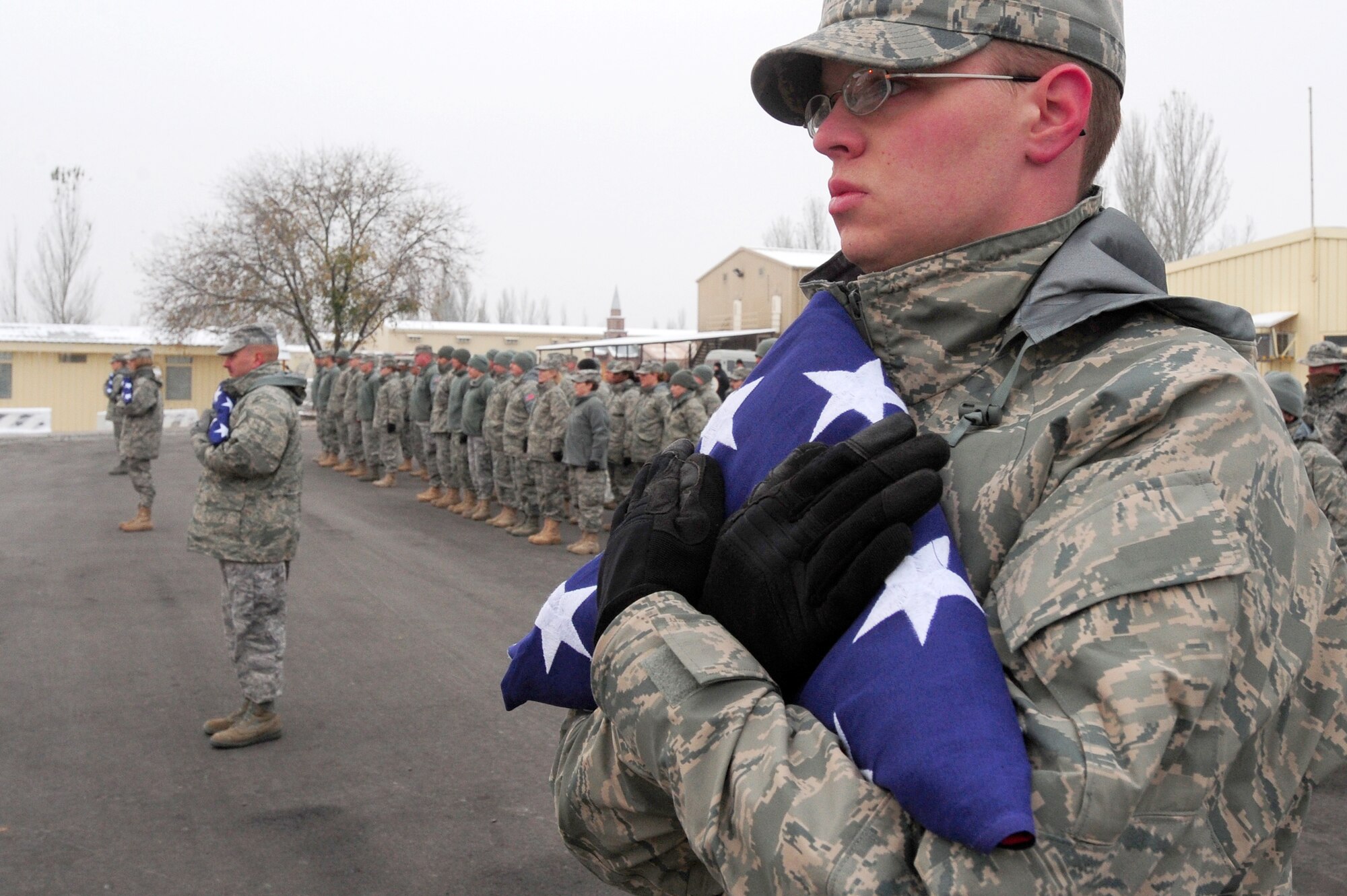 TRANSIT CENTER AT MANAS, Kyrgyzstan -- Senior Airman Zachary Merryman, 376th Expeditionary Medical Group radiology technician, holds the American flag tightly at a ceremony honoring those who've made the ultimate sacrifice since the terrorist attacks of 9/11. (U.S. Air Force photo/Senior Airman Steele C. G. Britton)