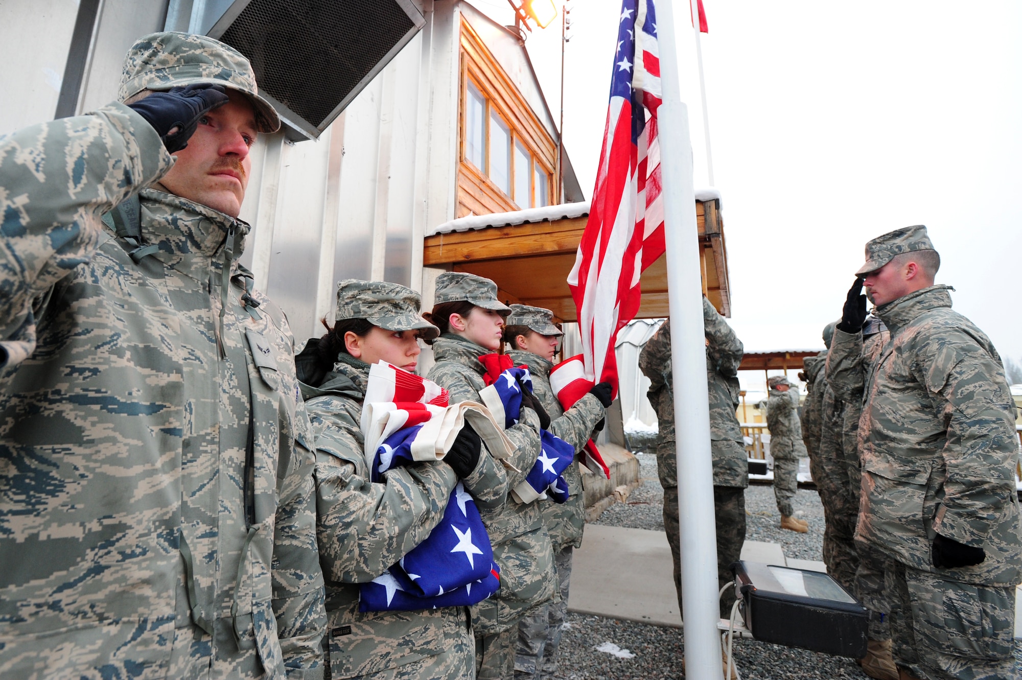 TRANSIT CENTER AT MANAS, Kyrgyzstan -- Honor guardsmen raise four American flags over the Transit Center on Veteran's Day for the family of N.Y. Fire Chief Peter Ganci Jr. who lost his life during the terrorist attacks of 9/11. Chief Ganci was saving his fourth victim when the second tower took his life in 2001. (U.S. Air Force photo/Senior Airman Steele C. G. Britton)
