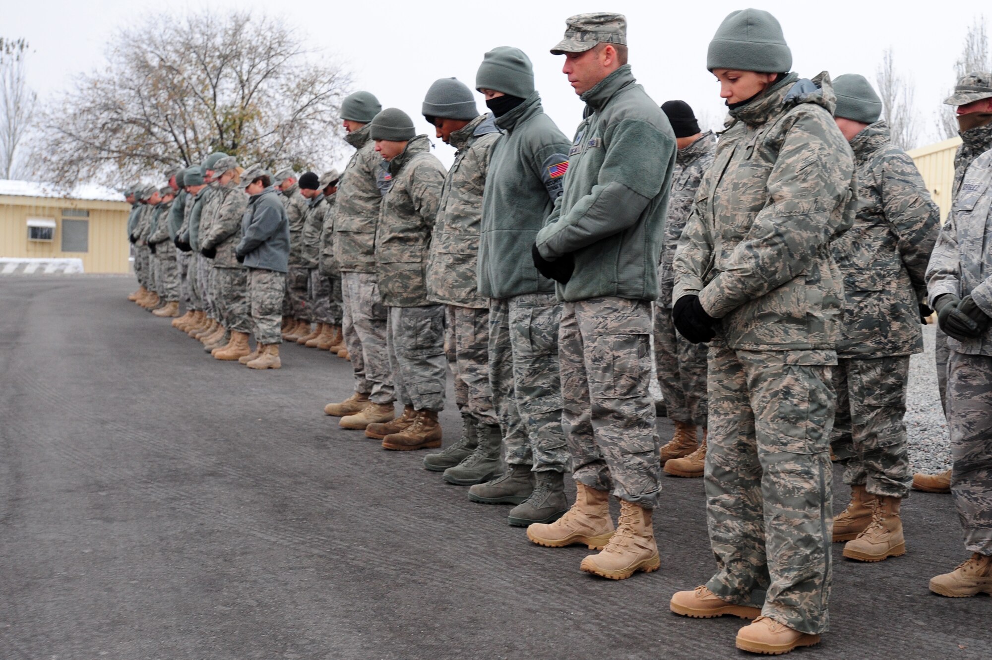 TRANSIT CENTER AT MANAS, Kyrgyzstan -- Airmen bow their heads in prayer at the Transit Center while remembering fallen N.Y. Fire Chief Peter Ganci Jr. and all those who lost their lives during the terrorist attacks of 9/11. (U.S. Air Force photo/Senior Airman Steele C. G. Britton)