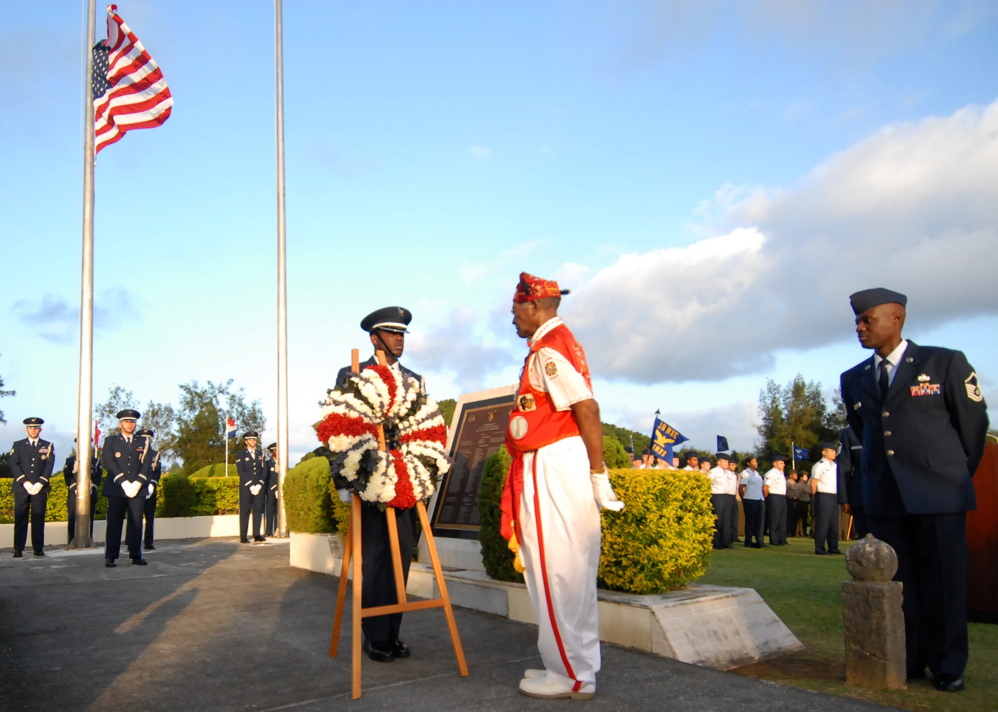 Tech. Sgt. Bronkelly Porter, 390th Intelligence Squadron information and quality assurance and Kadena Honor Guardsmen, presents a Veteran's Day wreath before Navy Petty Officer Third Class Harry Thomas, a World War II veteran, during a ceremony honoring the national holiday Nov. 11. Approximately 200 servicemembers, veterans, friends and family participated in the ceremony, including Mr. Thomas who spoke about the importance of military service and brotherhood that exists between those who have served in the past and those who continue to serve in the present. (Air Force/Staff Sgt. Jason Lake)