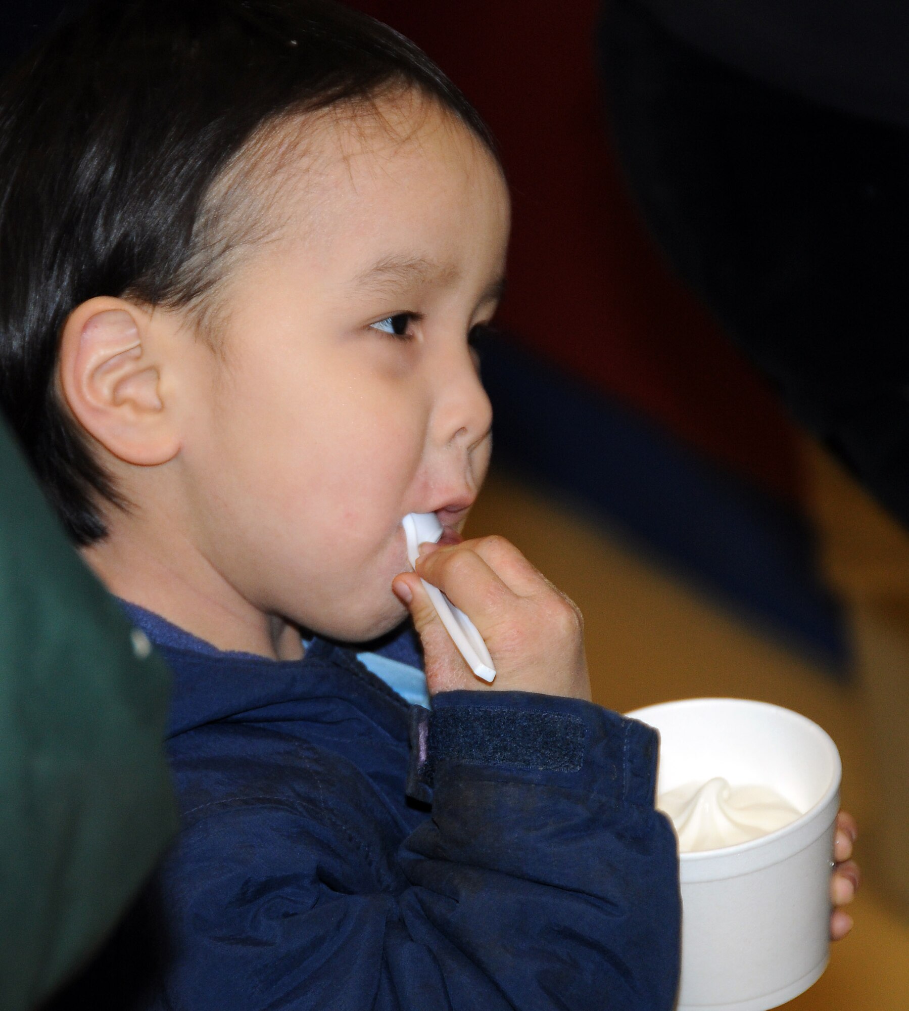 Cordell Merculief, 4, enjoys a rare taste of self-serve ice cream during an Operation Santa Claus visit Nov. 7. The ice cream was donated by the Tastee-Freez restaurant in Anchorage, which has a long history of supporting Operation Santa Claus and other military programs in Alaska. U.S. Air Force photo by 1st Lt. John Callahan.