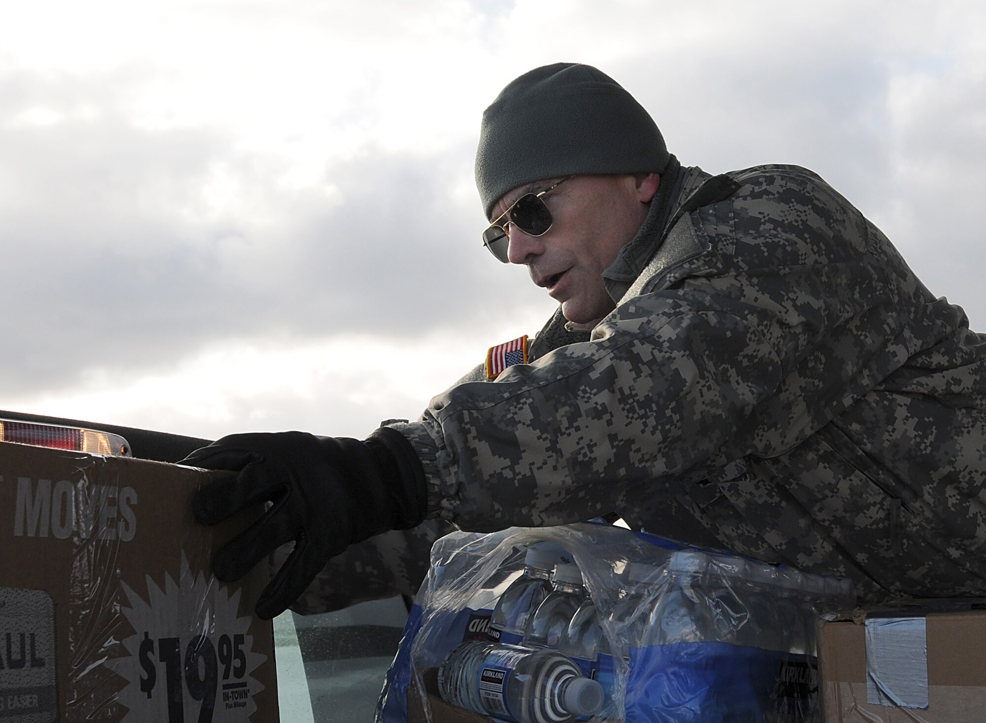 Brig. Gen. Thomas Katkus, then the acting adjutant general of the Alaska National Guard, stacks groceries in a pickup truck for transport to the St. George School. Gen. Katkus was named the Alaska National Guard's adjutant general three days later. U.S. Air Force photo by 1st Lt. John Callahan.