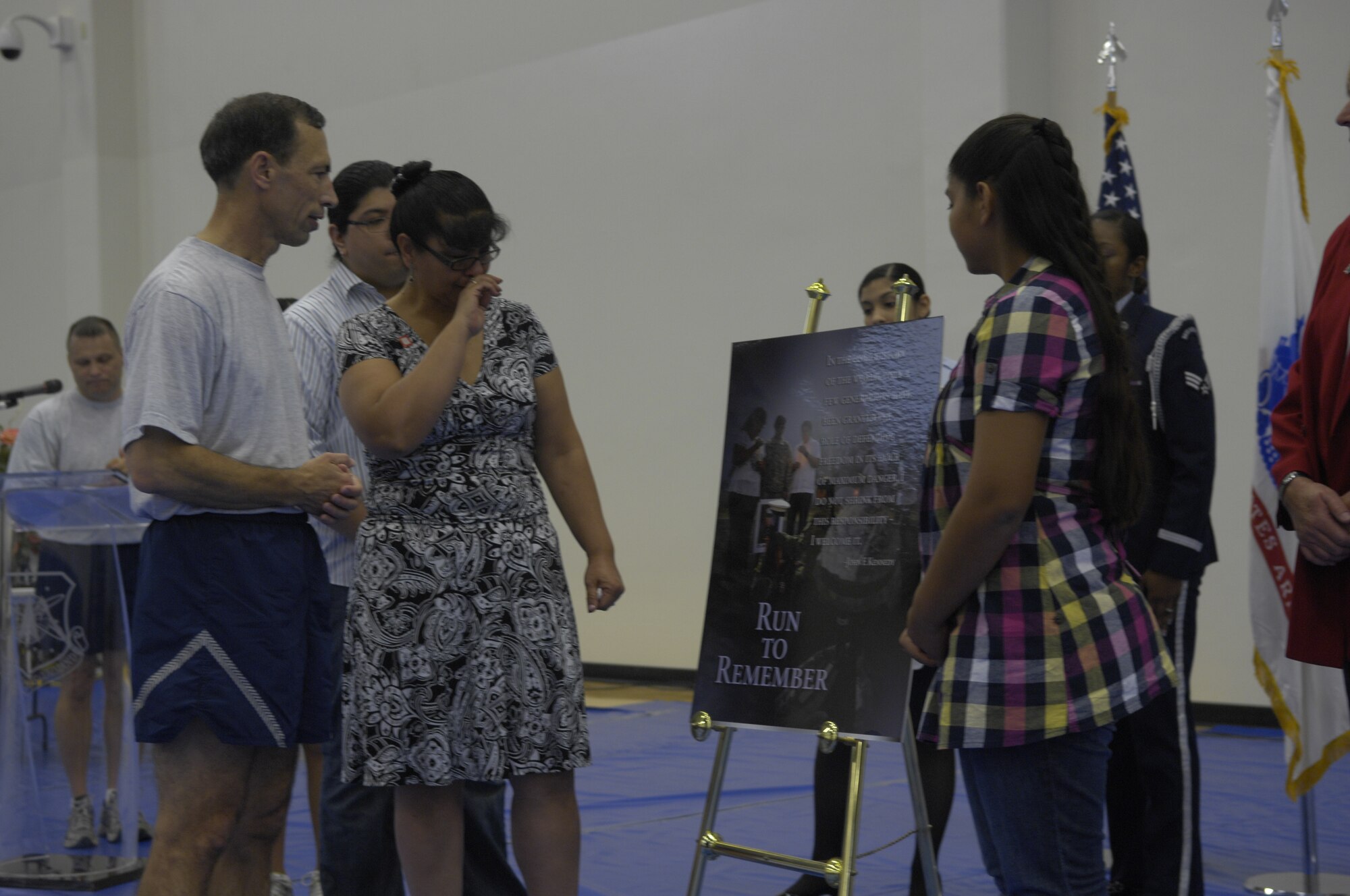 VANDENBERG AIR FORCE BASE, Calif. -- Lt. Gen. Larry James, 14th Air Force and the Joint Functional Component Command for Space commander, presents a collage of photos to Ms. Monica Diaz and her family during the closing ceremony of the Run to Remember here Wednesday, Nov. 11, 2009. Ms. Diaz, the mother of a fallen servicemember, has devoted her time and effort to make sure that this year’s and last year’s Run to Remember were successful. (U.S. Air Force photo/Staff Sgt. Levi Riendeau)
