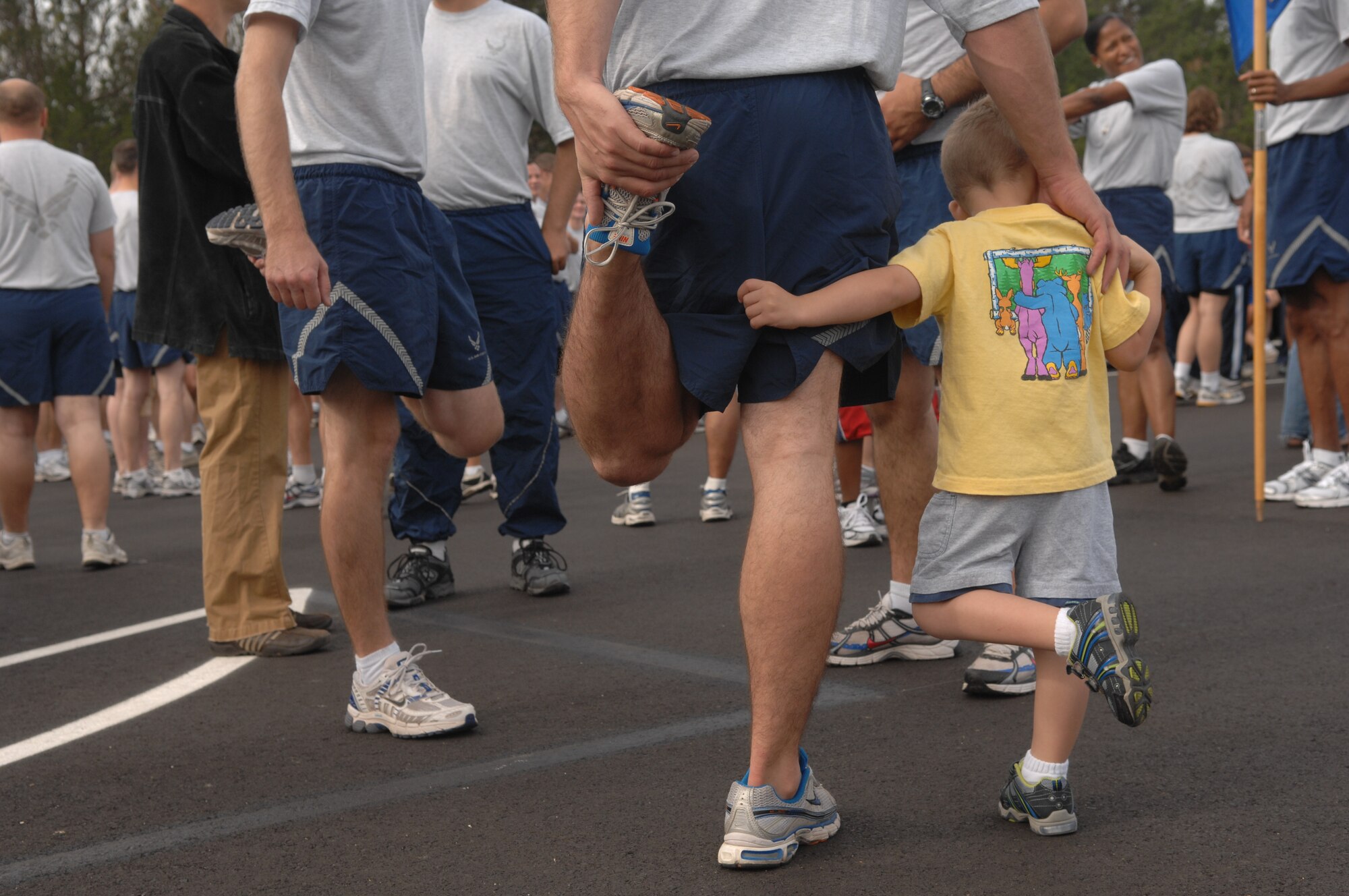 VANDENBERG AIR FORCE BASE, Calif. -- Leaning on his father, Ethan Roberts (right), and Staff Sgt. Jeff Roberts (center), of the 30th Civil Engineer Squadron, stretch before the final mile of the Run to Remember here Wednesday, Nov. 11, 2009. Held over the last three weeks, The Run to Remember, raised over $4000, involved military members running over 7000 miles to honor the over 5000 fallen American servicemembers during Operations Iraqi and Enduring Freedom. (U.S. Air Force photo/Staff Sgt. Levi Riendeau)