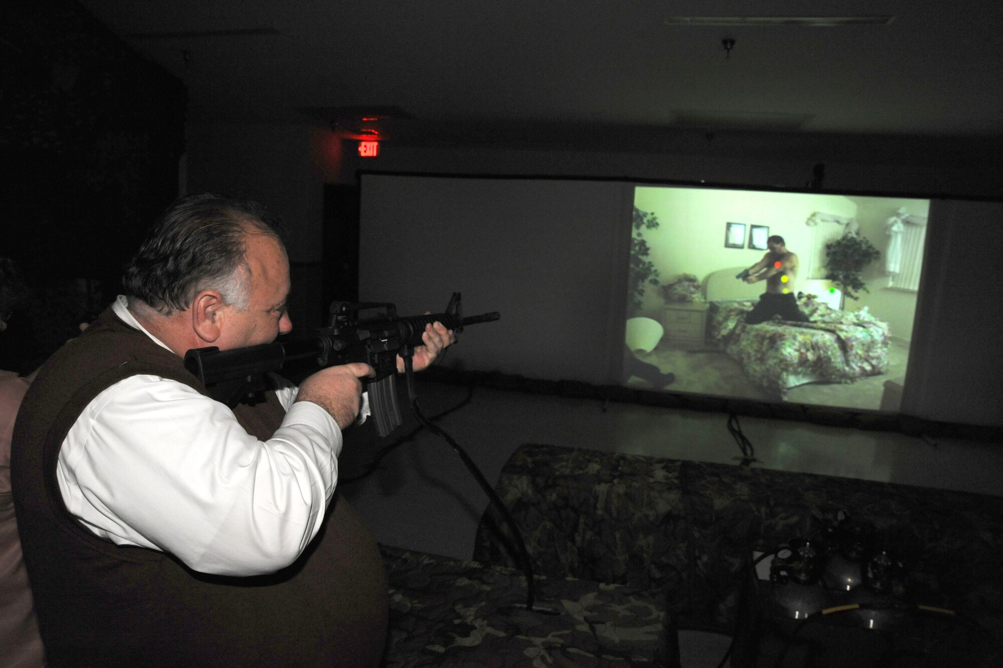 Robert Lee, a McConnell honorary commander, fires an M-4 rifle in the base fire arms training simulator Oct. 29, 2009, during an honorary commander orientation tour at McConnell Air Force Base, Kan. Each quarter, a different McConnell unit showcases its mission to honorary commanders through orientation tours. This quarter, the 22nd Mission Support Group hosted a tour. The tour consisted of a wing mission brief, and visits to base housing and dormitories, a deployment readiness mobility line and the firearms training simulator. (U.S. Air Force photo by Tech. Sgt. Chyrece Campbell)