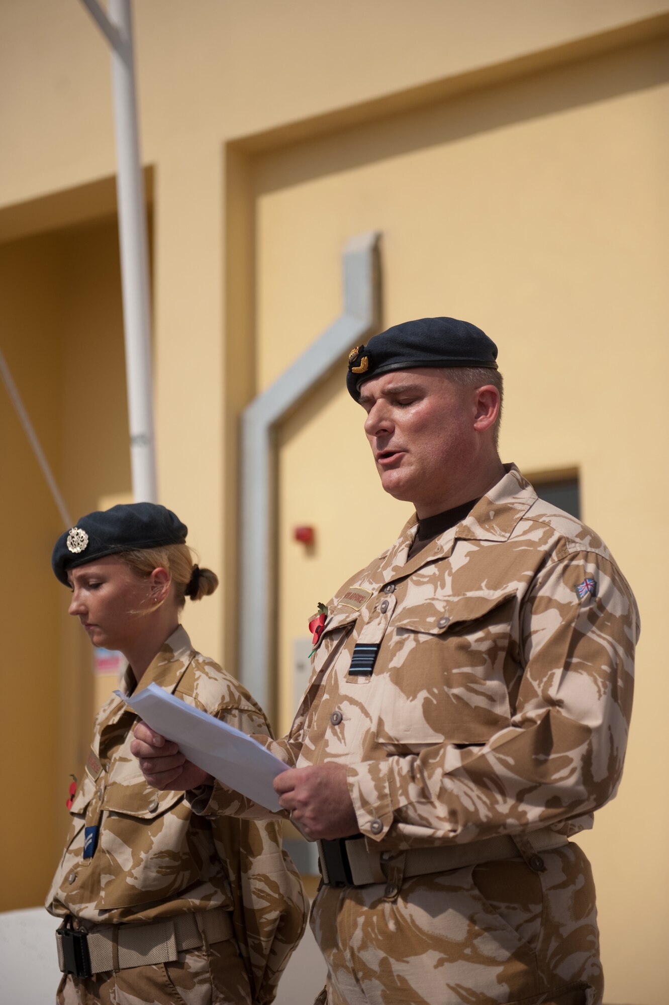 Royal Air Force Squadron Leader Paul Maple, 83rd Expeditionary Air Group, reads from the Book of Isaiah during a traditional Sunday Remembrance reflection ceremony in a deployed environment for Soldiers, Sailors and Airmen of the United Kingdom armed services, Nov. 8, 2009, in Southwest Asia. The RAF 83 EAG held a traditional Sunday Remembrance reflection ceremony to honor those who have made the ultimate sacrifice, reading the names of those killed over the last year and observing two minutes of silence. (U.S. Air Force photo/Staff Sgt. Robert Barney)  