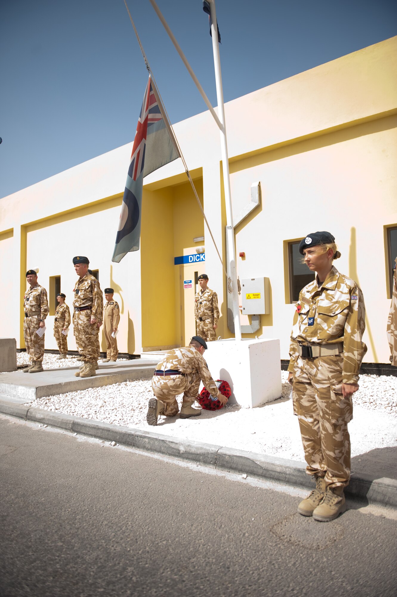 Royal Air Force Wing Commander Graham Muir, 83rd Expeditionary Air Group, lays a wreath of poppies during a traditional Sunday Remembrance reflection ceremony in a deployed environment for Soldiers, Sailors and Airmen of the United Kingdom armed services, Nov. 8, 2009, in Southwest Asia. RAF 83 EAG is holding a traditional Sunday Remembrance reflection ceremony to honor those who have made the ultimate sacrifice, reading the names of those killed over the last year and observing two minutes of silence. (U.S. Air Force photo/Staff Sgt. Robert Barney) 