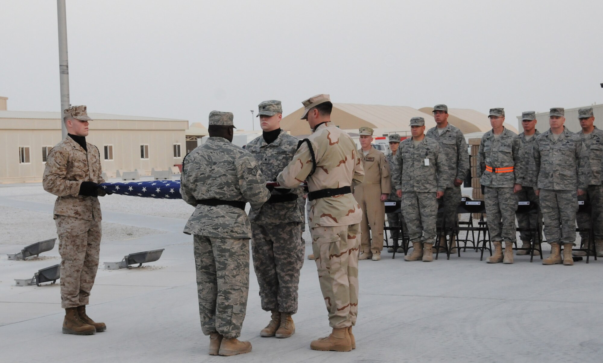 Base honor guard members fold the U.S. flag during the 379th Air Expeditionary Wing Veterans' Day retreat ceremony, Nov. 11, 2009, at a deployed location in Southwest Asia. Veterans' Day, also known as Armistice Day and Remembrance Day in other parts of the world, commemorates the end of World War I and honors both past and present veterans. (U.S. Air Force photo/Tech. Sgt. Jason W. Edwards)