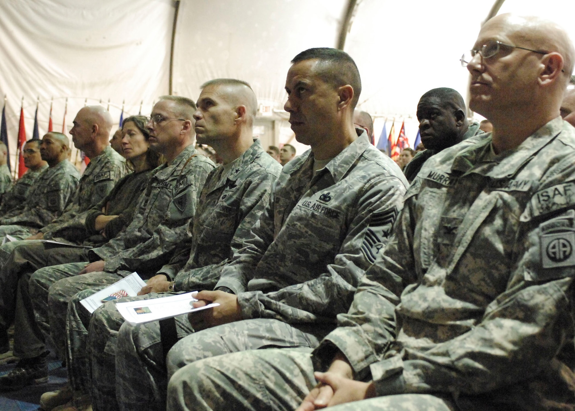 BAGRAM AIRFIELD, Afghanistan -- Brigadier General Steve Kwast, 455th Air Expeditionary Wing commander and Chief Master Sgt. Jeffrey Cui, 455th AEW command chief listen to Army Sgt. First Class Raleigh Sell, the protocol non-commissioned officer in charge from Combined Joint Task Force 82, speak about previous veterans from America's past wars.  Sergeant Sell spoke at the Veteran's Day Ceremony Nov. 11, 2009.  (U.S. Air Force photo/Senior Airman Felicia Juenke)