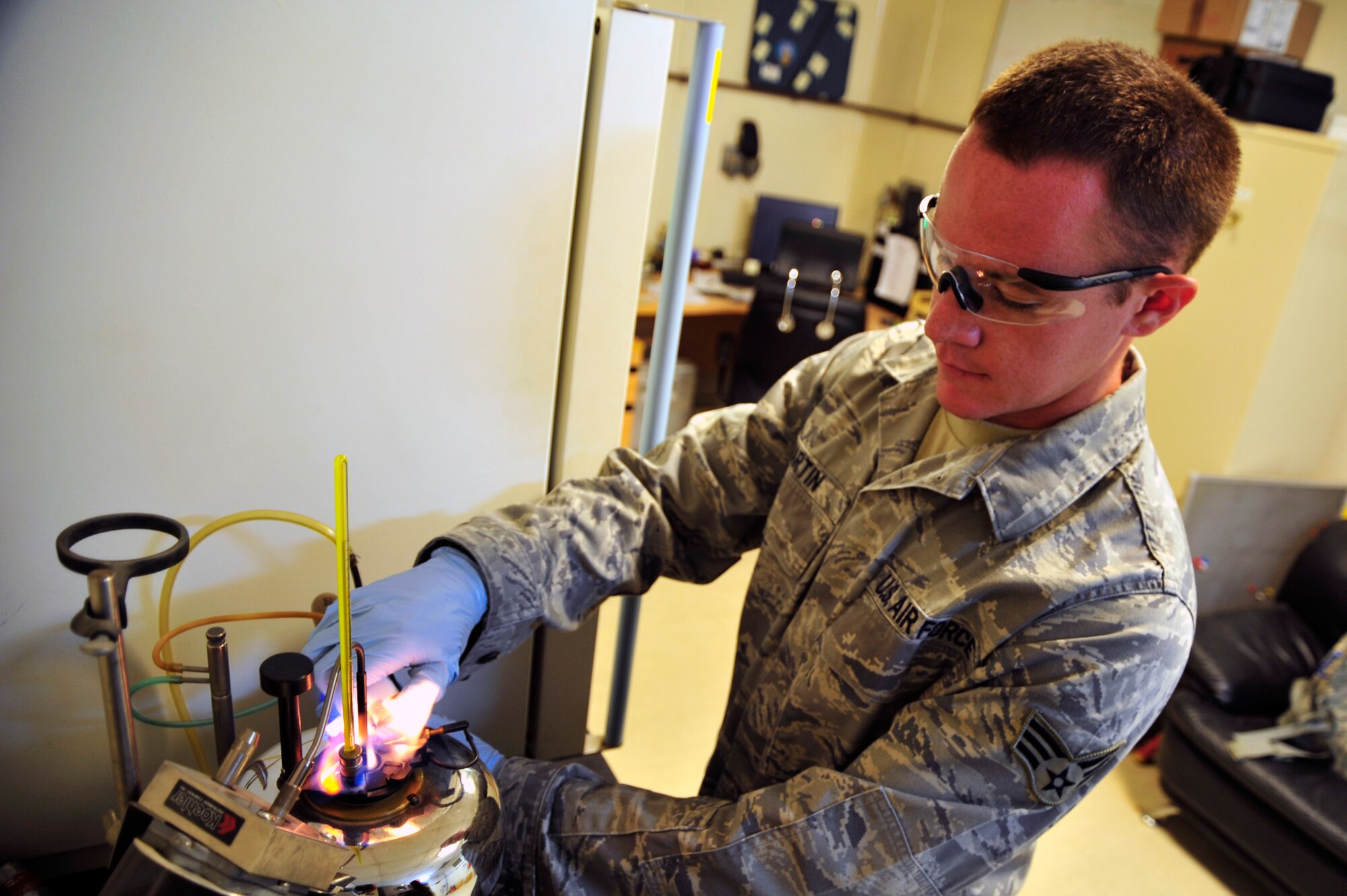 SOUTHWEST ASIA -Senior Airman Levi Martin, 380th Expeditionary Logistics Readiness Squadron fuel laboratory technician, ignites a pilot light on a flash point tester Nov. 10, 2009. Airman Martin is deployed from Dover Air Force Base, Del., and grew up in Crestview, Fla. (U.S. Air Force photo/Tech.Sgt. Charles Larkin Sr)
