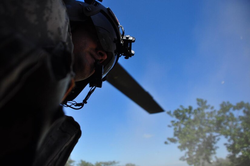 ILOPANGO, El Salvador -- Army Staff Sgt. Mario Sarria, a CH-47 Chinook flight engineer assigned to Joint Task Force-Bravo, scans a landing zone prior to take off Nov. 12. JTF-Bravo members, based out of Soto Cano Air Base, Honduras, helped distribute more than 21,000 pounds of food, water, clothing and other hygiene products to villages of El Salvador that have been cut off by mudslides. The towns most affected by the Nov. 8 flooding were Verapaz, Guadalupe, Santa Maria Ostumas and San Vicente. These villages were completely cut off by damaged roads and bridges (U.S. Air Force photo/Staff Sgt. Chad Thompson).