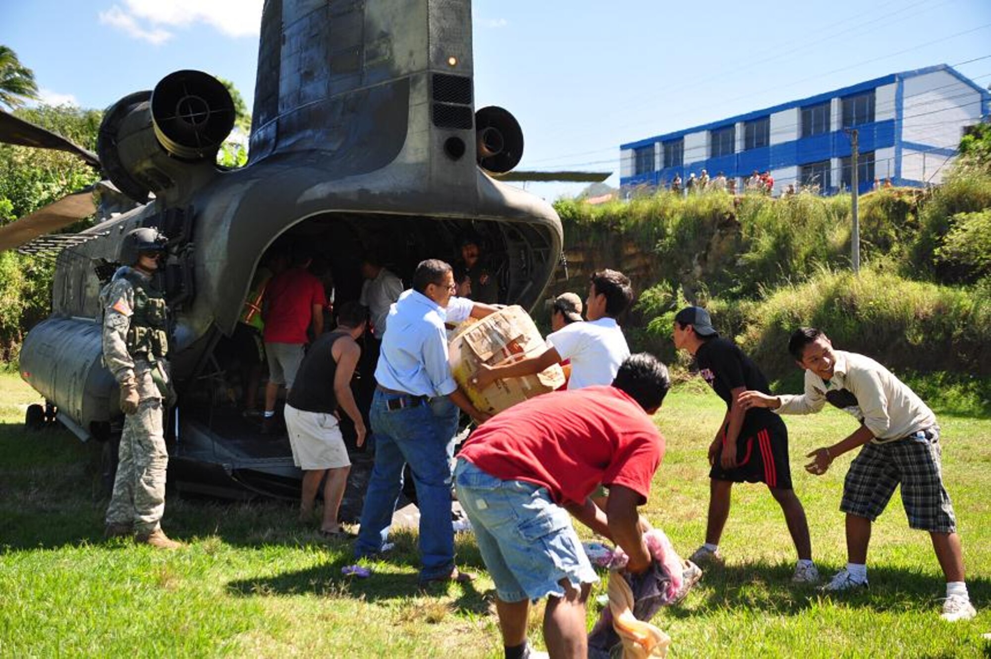 ILOPANGO, El Salvador -- Villagers from Verapaz, El Salvador, unload a CH-47 Chinook assigned to Joint Task Force-Bravo Nov. 12. JTF-Bravo members, based out of Soto Cano Air Base, Honduras, helped distribute more than 21,000 pounds of food, water, clothing and other hygiene products to villages of El Salvador that have been cut off by mudslides. The towns most affected by the Nov. 8 flooding were Verapaz, Guadalupe, Santa Maria Ostumas and San Vicente. These villages were completely cut off by damaged roads and bridges (U.S. Air Force photo/Staff Sgt. Chad Thompson).