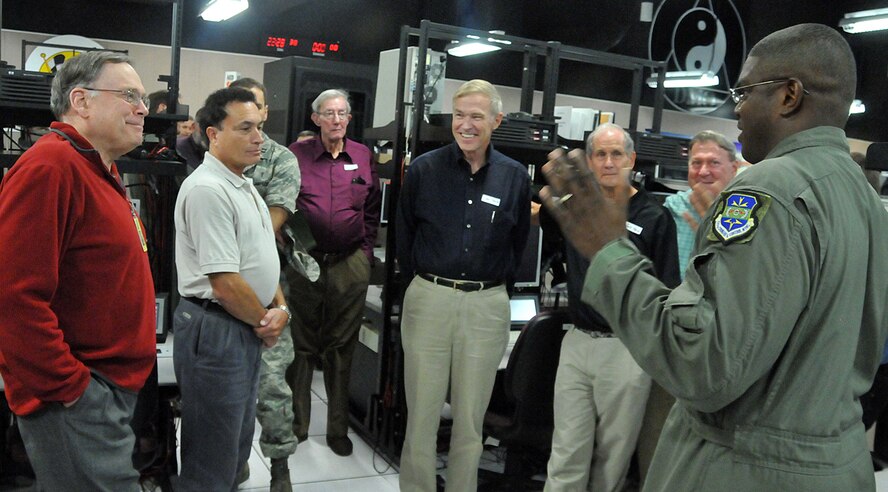 Master Sgt. Timothy Teamer, right, 705th Combat Training Squadron, gives a briefing to retired Air Force Chief of Staff Gen. John Jumper, left, and others about a high tech program and the equipment associated with it, Nov. 6. General Jumper was taking a tour of the Distributed Mission Operations Center and was here as the guest speaker for their 30 Anniversary dinner later that evening.  U.S. Air Force photo by Todd Berenger