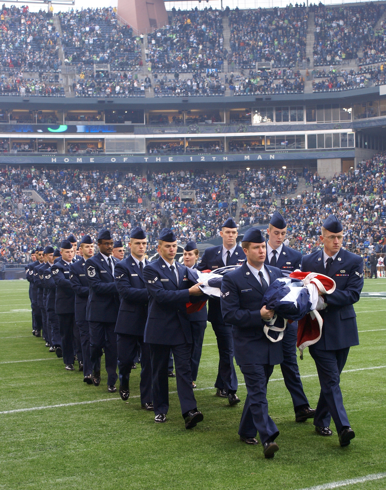 SEATTLE - Airmen from McChord Air Force Base, Wash.,, including 14 people from the 446th Airlift Wing, walk a large American flag onto the field at the Nov. 8 Seattle Seahwaks game against the Detroit Lions.  The Seahawks paid tribute to the military services during pre-game activities. Servicemembers from each military branch were honored for their service to the country.  (U.S. Air Force photo/Staff Sgt. Eric Burks)                  