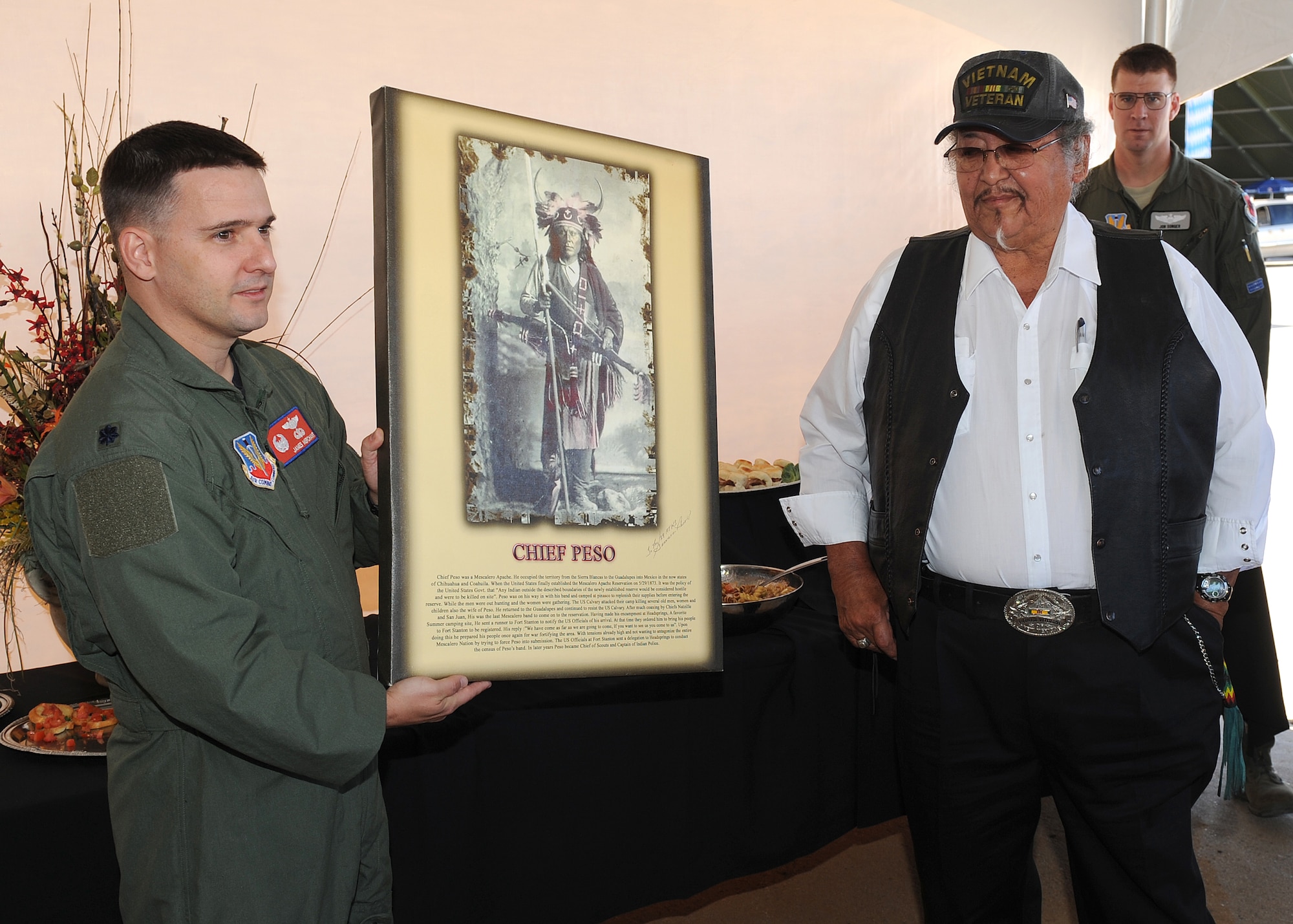 HOLLOMAN AIR FORCE BASE, N.M. -- The patch artist Gervase Peso, Mescalero Indian tribe presents Lt. Col. James Merchant, 29th Attack Squadron commander with a painting of the last Chief of the Mescalero Apache Tribe, Oct. 23. The 29th ATKS asked the Mescalero Apache to design a patch for their newly activated squadron. (U.S. Air Force photo by Senior Airman Michael Means)