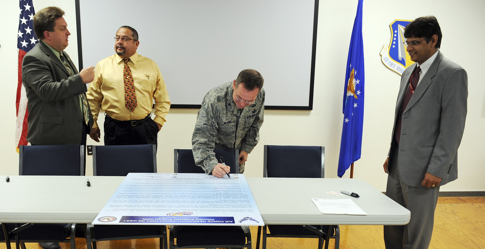 Col. David Blanks, Air Force Research Laboratory Detachment 7  commander,  signs a Voluntary Protection Program commitment agreement Nov. 10. The VPP promotes work site safety and health. In the VPP, management, labor and Occupational Safety and Health Administration establish cooperative relationships at workplaces that have implemented a comprehensive safety and health management system. (Air Force photo/Ronald Fair)